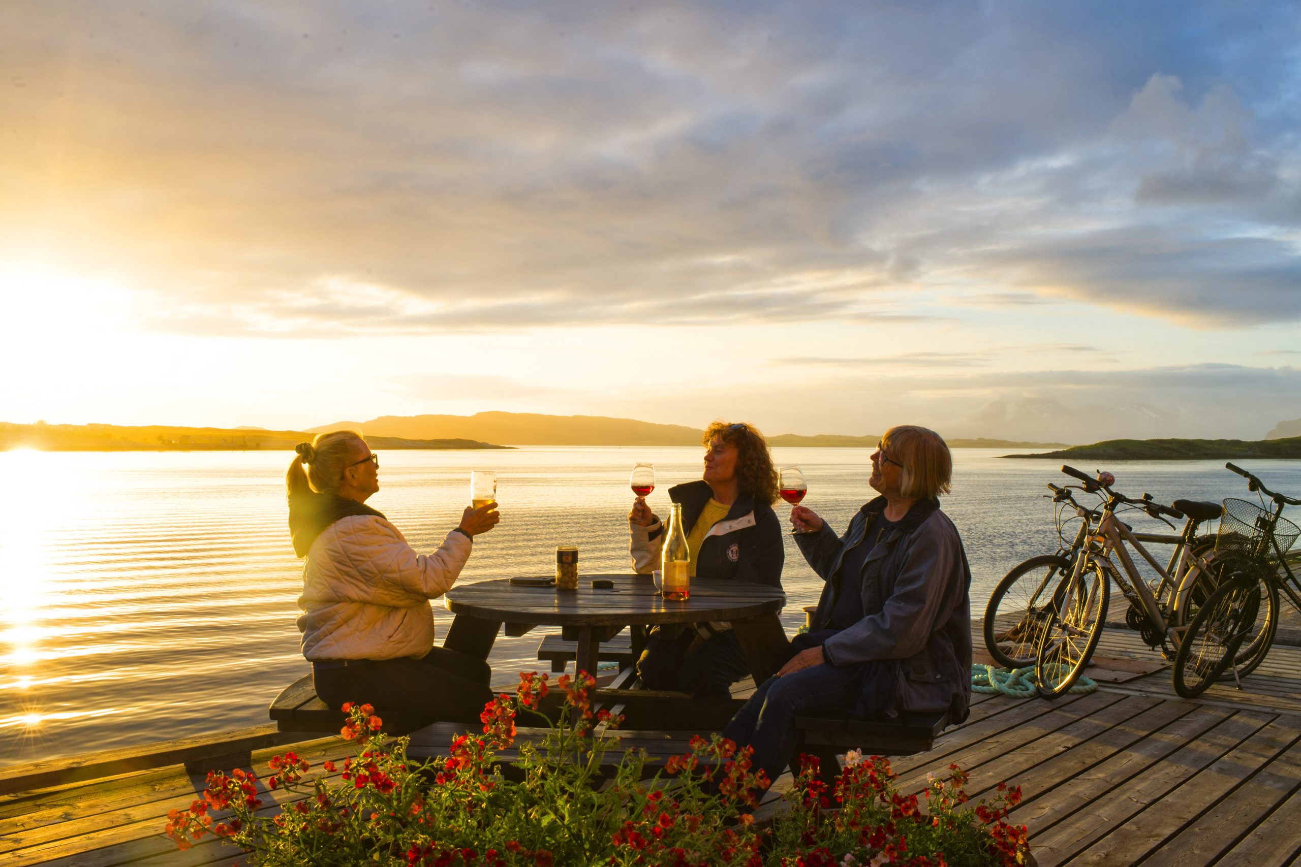 Syklister nyter drikke på brygge